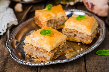 Walnuts baklava in oriental tray on wooden background. East sweets. Ramadan food. Selective focus