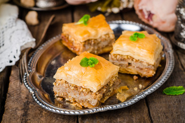 Walnuts baklava in oriental tray on wooden background. East sweets. Ramadan food. Selective focus