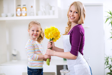 Happy mother and daughter with flowers