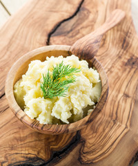 Mashed potatoes in the wooden bowl on the service tray.
