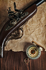 Ancient pistol and brass compass