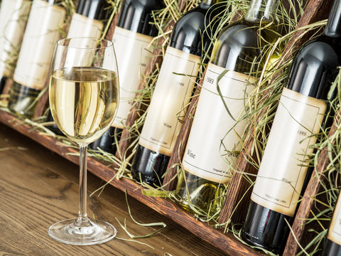 Wine bottles on the wooden shelf.