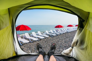 View from inside a tent on the sun loungers on a beach
