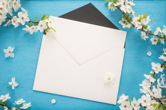   Flowers and envelope on wooden background 