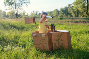 toddler girl playing with paperboard ship