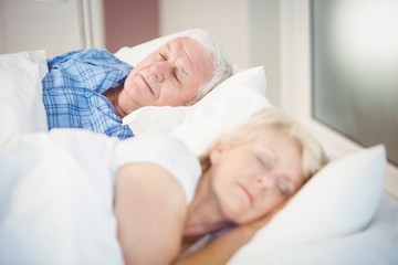 Fototapeta na wymiar High angle view of senior couple sleeping on bed