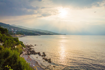 Fototapeta premium beautiful sunrise on the sea with seagulls and holiday-makers 