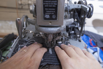 25 September 2012 at a tailor in Barcelona, Spain. Production process of suit tailoring. Sewing of...