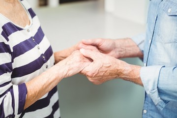 Midsection of senior couple holding hands