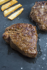cooked beef chateaubriand steak with chunk chipped potatoes on p