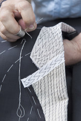 25 September 2012 at a tailor in Barcelona, Spain. Production process of suit tailoring, hand sewing of a tailored jacket
