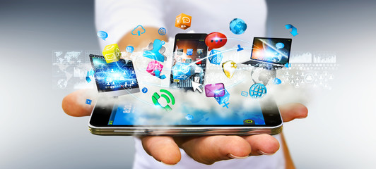 Businessman holding tech devices and icons applications over a c © sdecoret