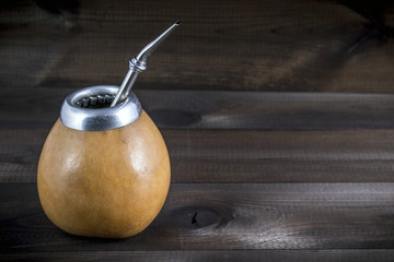 Yerba mate with bombilla on wooden background