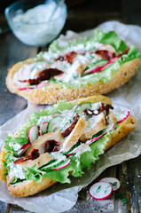 Healthy chicken sandwiches on wooden background close up.