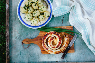 Chicken sausages on a wooden cutting board.