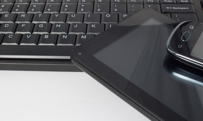 Close up of tablet, keyboard and mobile phone isolated on white