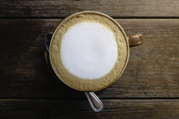 cup of fresh cappuccino on the oak table