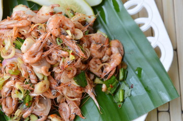 prawn spicy salad with herb on fresh banana leaf