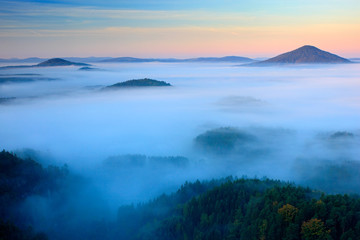 Fototapeta premium Cold misty foggy morning in a fall valley of Bohemian Switzerland park. Hills with fog, landscape of Czech Republic