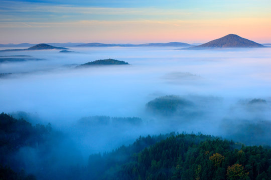 Cold misty foggy morning in a fall valley of Bohemian Switzerland park. Hills with fog, landscape of Czech Republic