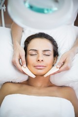 Close-up of woman receiving facial massage at spa