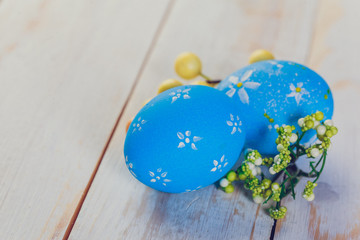 Easter eggs painted in pastel colors on white wooden background.