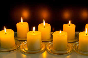 closeup to burning candles in darkness