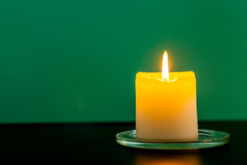 Colorful scented candles on a dark green background