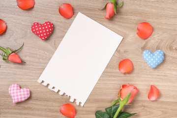 Bouquet of pink red roses and greeting card on a wooden background