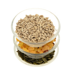 sunflower seeds ,raisins ,pumpkin seeds in a glass bowl. Isolated on white.