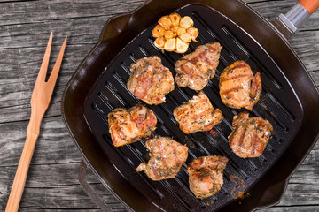pieces of grilled meat on a skillet, top view