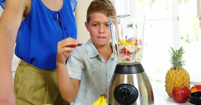 Mother and son preparing juice