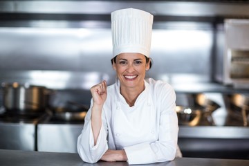 Portrait of smiling female chef in kitchen