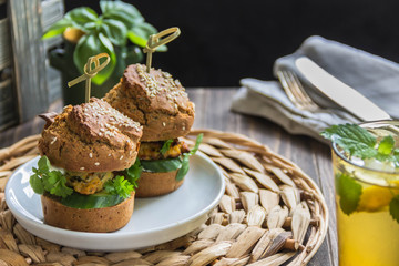 Healthy Burgers with chicken cutlet, basil and parsley, a roll of rye flour with sesame seeds.