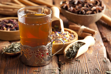 Cup of tea and tea leaves on wooden table