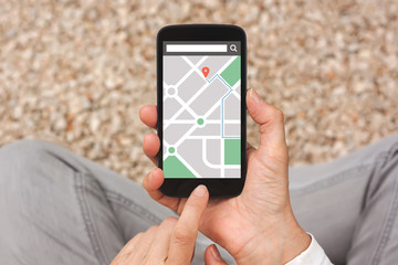 Hands holding smart phone with map gps navigation application on screen. All screen content is...