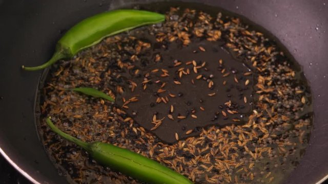 Cook prepares the base for a Indian masala mix with curry leaf