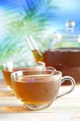 Cup of tea and teapot on nature background