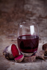 Fresh beetroot juice in a glass with rusty background
