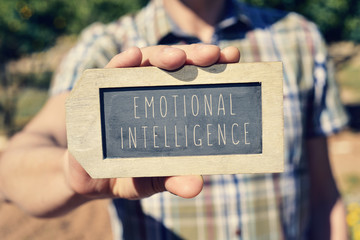 man with a chalkboard with the text emotional intelligence - obrazy, fototapety, plakaty