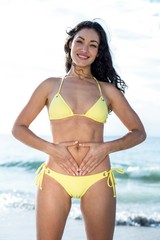 Obraz premium Portrait of happy woman in bikini touching belly