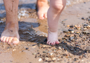 Fototapeta na wymiar Mother and child feet on a sandy beach