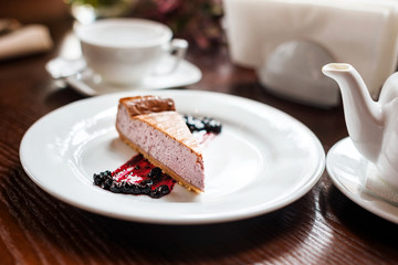 Blueberry cheesecake on white plate in cafe.