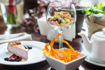 Blueberry cheesecake and fruit salad with granola in cafe.