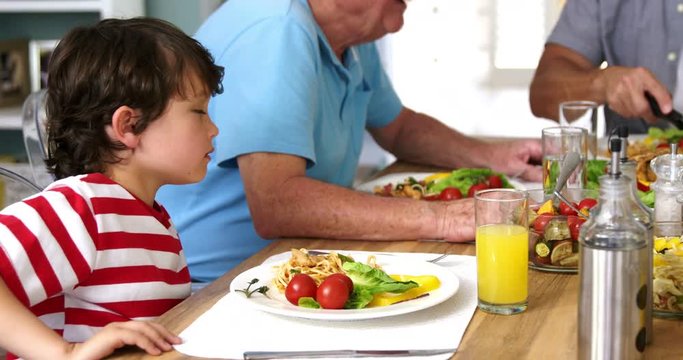 Happy multi-generation family eating at table