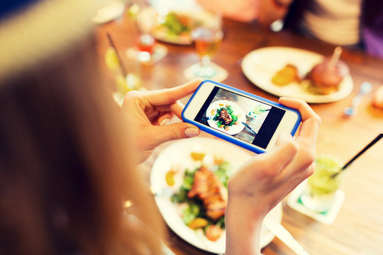 woman photographing food by smartphone 