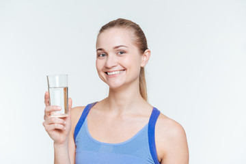 Smiling fitness woman holding glass with water