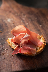 Ham with slice of bread on wooden board