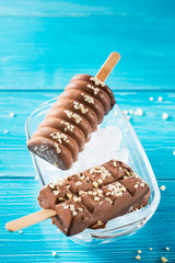 Two chocolate popsicles with nuts