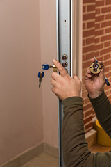 Cerrajero cambiando una cerradura en puerta acorazada 2.